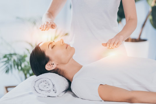 Glowing reiki healing hands over a person